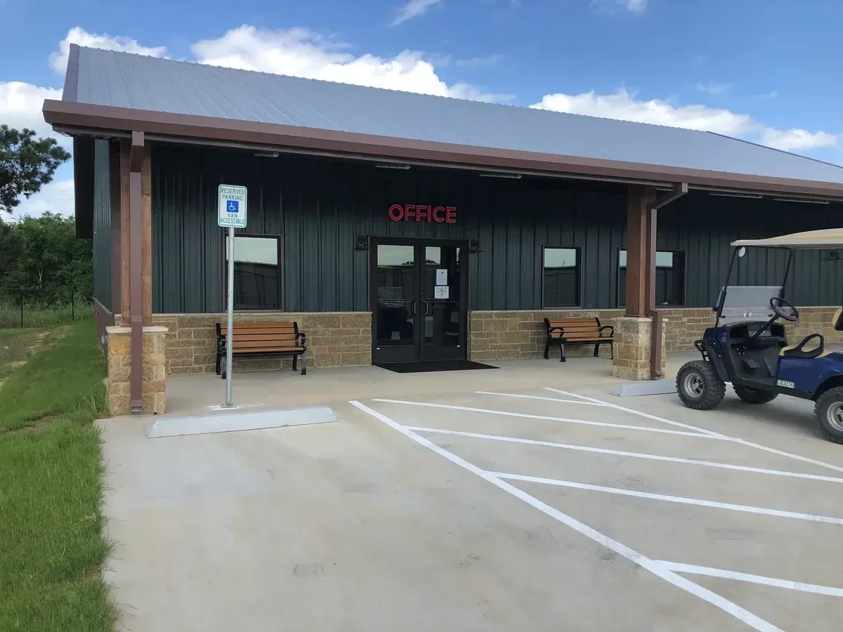 Building exterior with park benches and an office sign